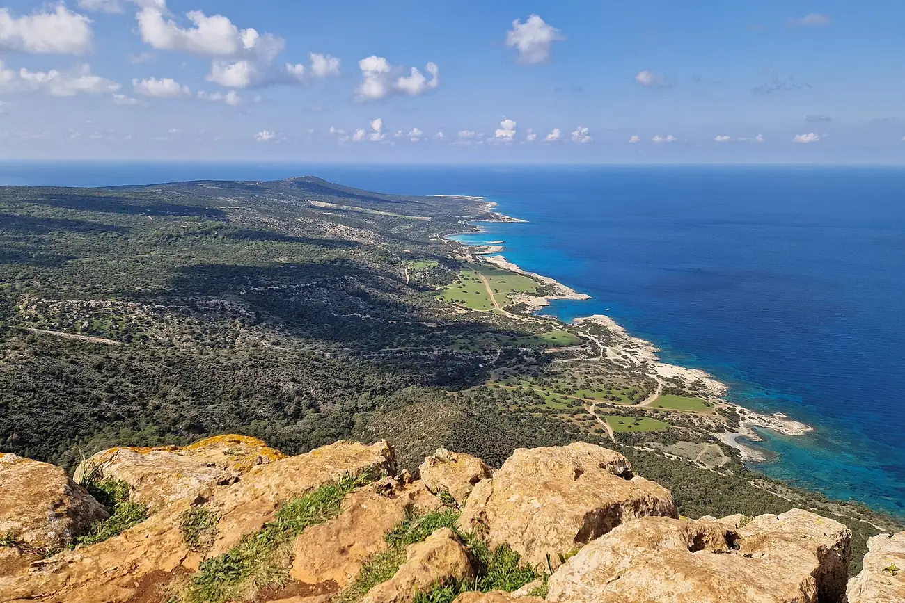 View from the Aphrodite nature trail over golden rocks to the green Akamas peninsula and its coast