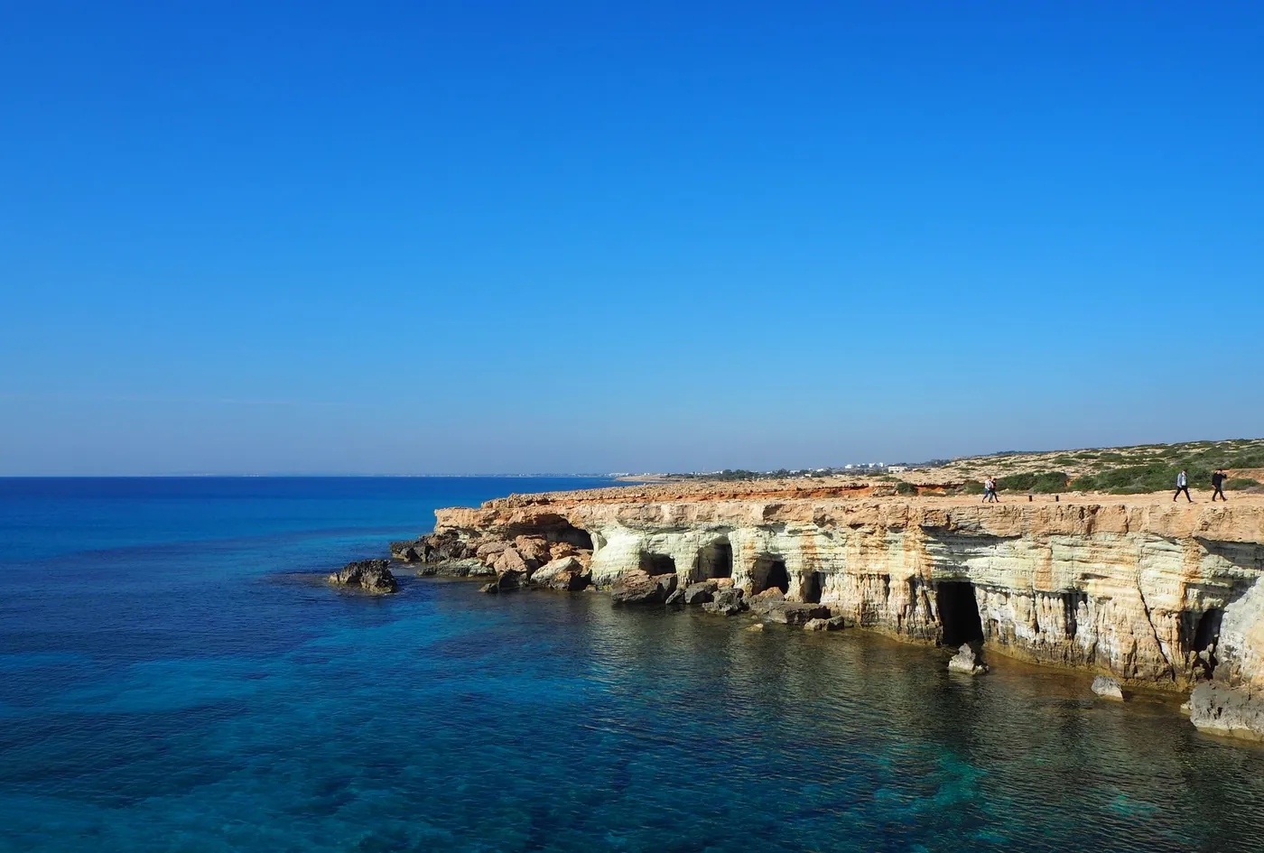 Limestone sea caves and low cliffs near Ayia Napa under a clear blue sky